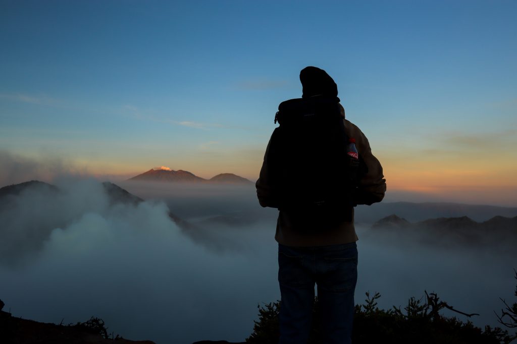 Mann bei Sonnenaufgang am Krater des Ijen Vulkans auf Java in Indonesien.